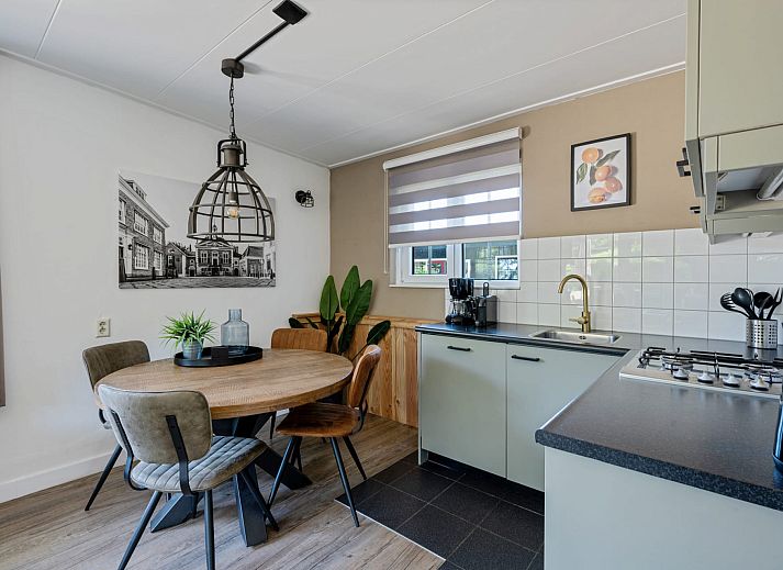 Terrace at Bungalow Middelharnis in Ouddorp, Goeree-Overflakkee with comfortable deck chairs and dining table.