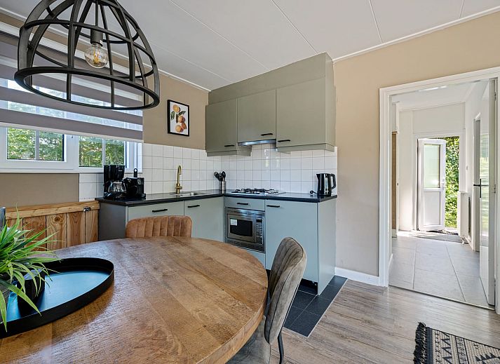 Terrace at Bungalow Middelharnis in Ouddorp, Goeree-Overflakkee with comfortable deck chairs and dining table.