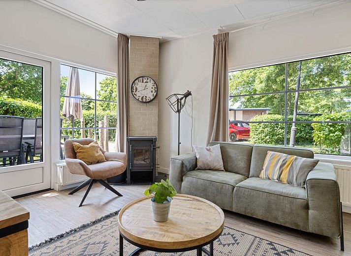 Terrace at Bungalow Middelharnis in Ouddorp, Goeree-Overflakkee with comfortable deck chairs and dining table.