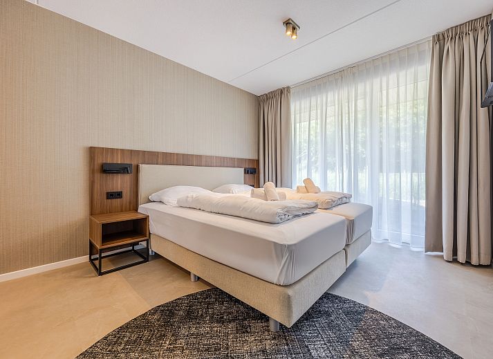 Zonnige woonkamer met grote ramen in het 2-persoons appartement 2L, Ouddorp, Goeree-Overflakkee, biedt uitzicht op de duinen.