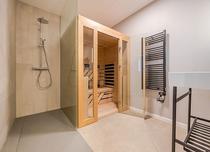 Elegant ingerichte zithoek in het 2-persoons appartement 2L, Ouddorp, met een moderne tv en stijlvolle decoratie.