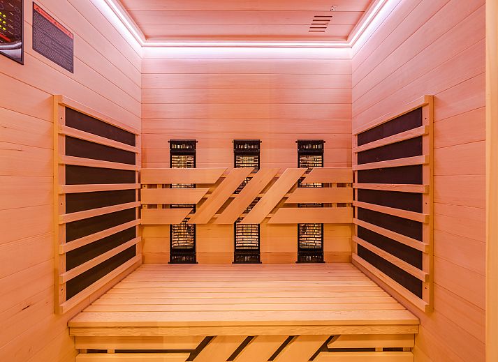 Elegant ingerichte zithoek in het 2-persoons appartement 2L, Ouddorp, met een moderne tv en stijlvolle decoratie.