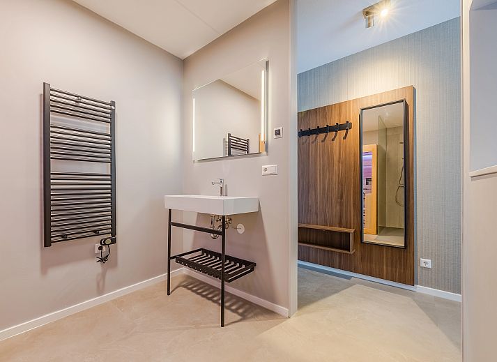 Elegant ingerichte zithoek in het 2-persoons appartement 2L, Ouddorp, met een moderne tv en stijlvolle decoratie.