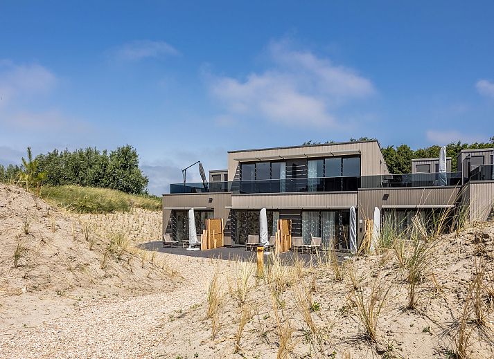 Elegant ingerichte zithoek in het 2-persoons appartement 2L, Ouddorp, met een moderne tv en stijlvolle decoratie.