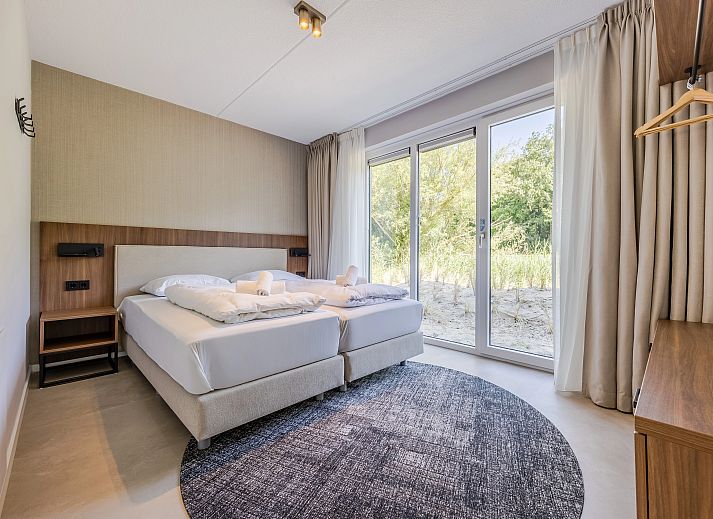 Stilvolle Sitzecke in der 2-4-Bett-Wohnung 2-4C, Ouddorp, Goeree-Overflakkee, mit moderner Kunst an der Wand.