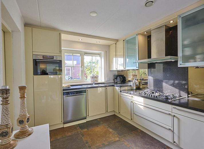 Gezellige woonkamer in Villa Robinie, vakantiehuis in Oude-Tonge, met open haard en ruime zithoek, Goeree-Overflakkee.