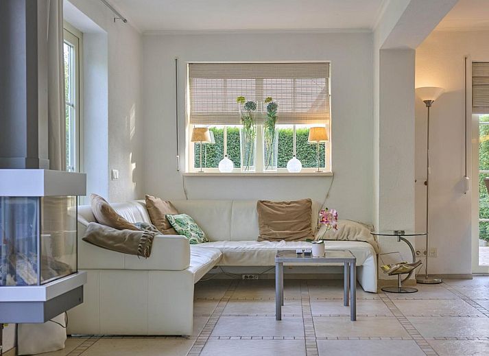 Gezellige woonkamer in Villa Robinie, vakantiehuis in Oude-Tonge, met open haard en ruime zithoek, Goeree-Overflakkee.