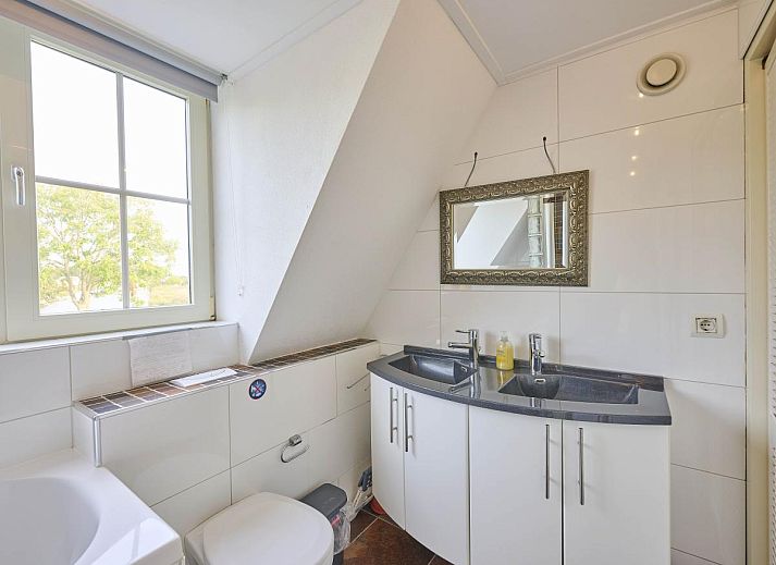 Lichte slaapkamer in Villa Robinie, vakantiehuis in Oude-Tonge, Goeree-Overflakkee, met modern interieur en groot raam.