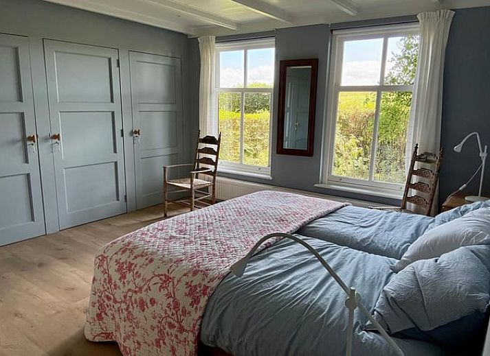 Gemuetliches Ferienhaus in Goedereede mit roten Dachziegeln und gruener Hecke in Suedholland.