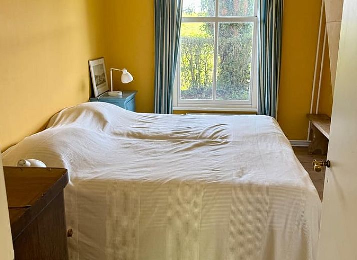 Gemuetliches Ferienhaus in Goedereede mit roten Dachziegeln und gruener Hecke in Suedholland.