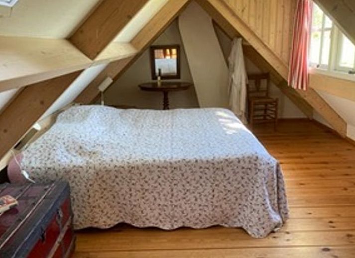 Gemuetliches Ferienhaus in Goedereede mit roten Dachziegeln und gruener Hecke in Suedholland.