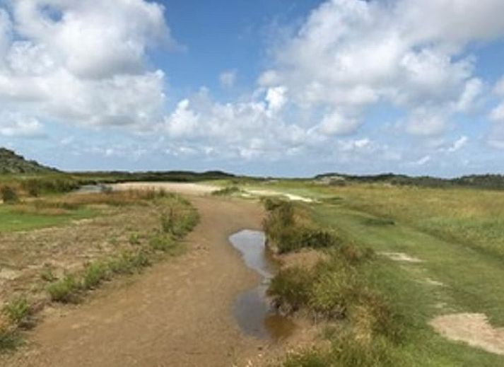 Terrasse des Ferienhauses in Goedereede mit Holzmoebeln und Sonnenschirm auf Goeree-Overflakkee.