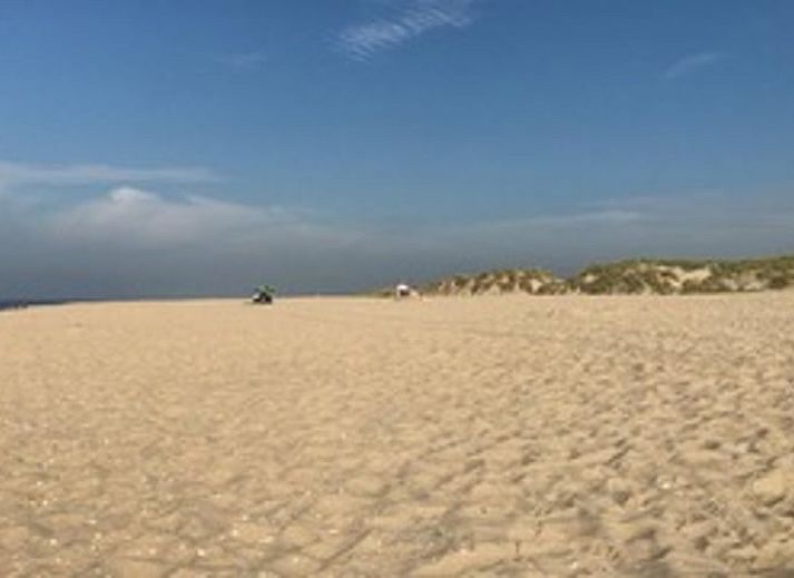 Terrasse des Ferienhauses in Goedereede mit Holzmoebeln und Sonnenschirm auf Goeree-Overflakkee.