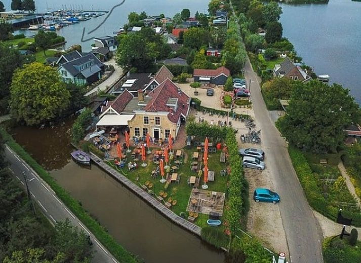 Gezellige zitruimte in Vakantiehuisje in Reeuwijk, Groene hart, Zuid-Holland, met stijlvolle houten muren en comfortabele fauteuils.
