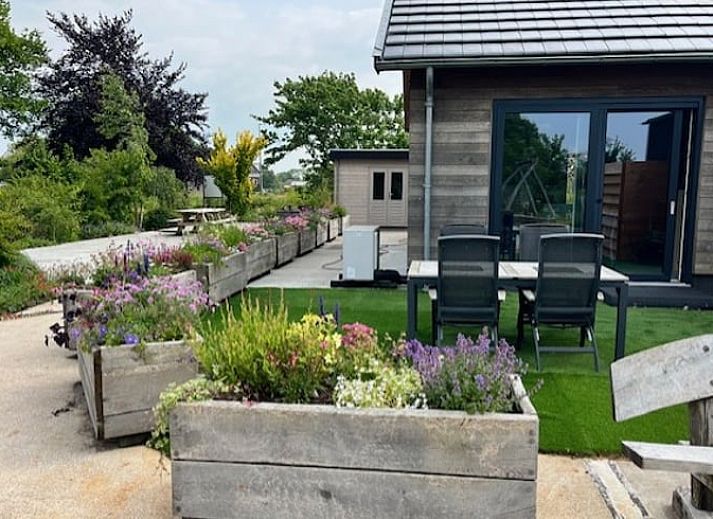 Cottage in Noorden, Green Heart, South Holland with wooden facade and colorful flower boxes, surrounded by lush nature.