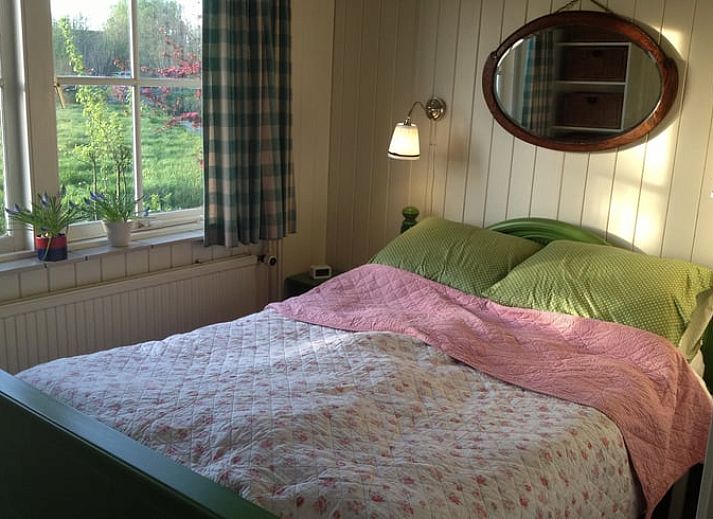 Vakantiehuisje in Vlist, gelegen in het Groene Hart van Zuid-Holland, met een prachtige tuin en schommelbank omringd door natuur.