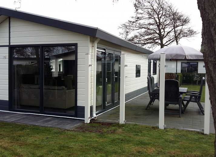 Geniessen Sie den sonnigen Garten des Chalets Duinparel 126 in Noordwijk, Suedholland, mit Terrasse und Blick auf die Natur.