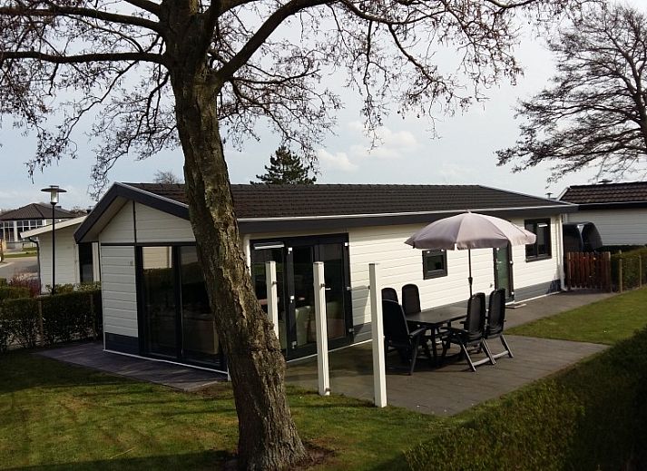 Geniessen Sie den sonnigen Garten des Chalets Duinparel 126 in Noordwijk, Suedholland, mit Terrasse und Blick auf die Natur.