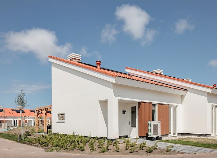 Stijlvolle woonkamer van Bungalow 6B in Noordwijkerhout, Noordzeekust, Zuid-Holland met moderne meubels en uitzicht op de tuin.