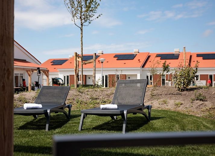 Stijlvolle woonkamer van Bungalow 6B in Noordwijkerhout, Noordzeekust, Zuid-Holland met moderne meubels en uitzicht op de tuin.