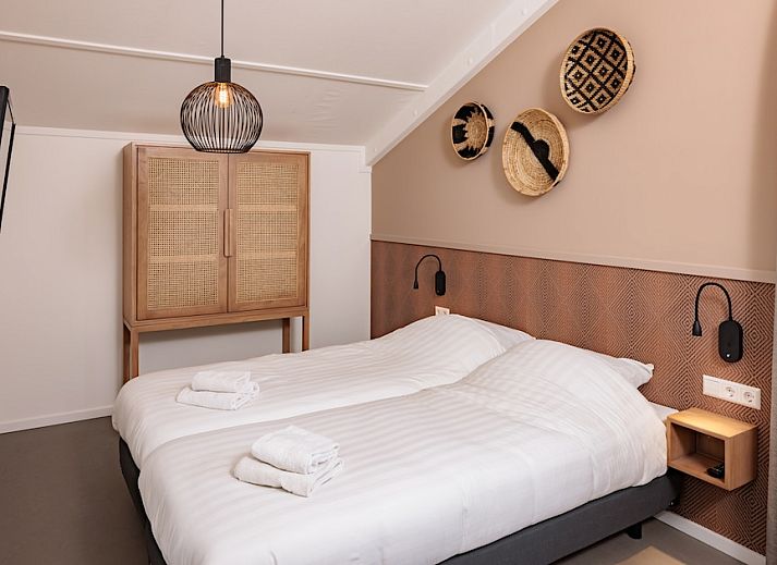 Stilvolles Wohnzimmer im Bungalow 8, Noordwijkerhout, Nordseekueste, mit gemuetlicher Sitzecke und Blick auf die Terrasse.