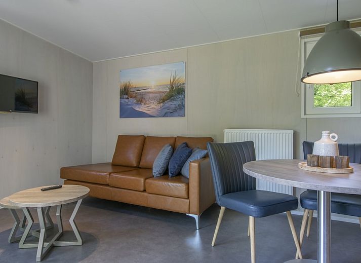 Comfort 2 Mindervalide chalet met veranda in Kijkduin, Noordzeekust, Zuid-Holland omgeven door groen.