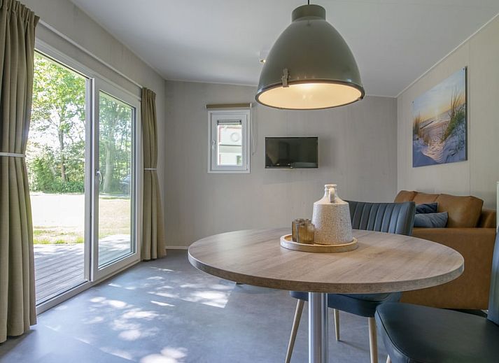 Comfort 2 Mindervalide chalet met veranda in Kijkduin, Noordzeekust, Zuid-Holland omgeven door groen.