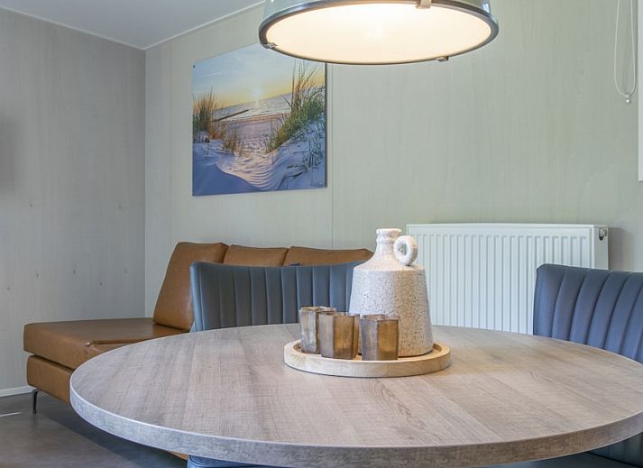 Gezellige woonkamer in Comfort 2 Mindervalide chalet, Kijkduin, met comfortabele zithoek en decoratie.