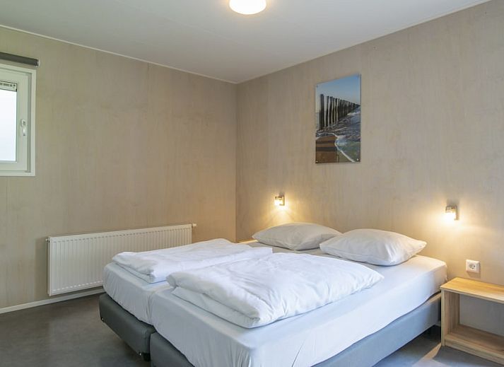 Gezellige woonkamer in Comfort 2 Mindervalide chalet, Kijkduin, met comfortabele zithoek en decoratie.