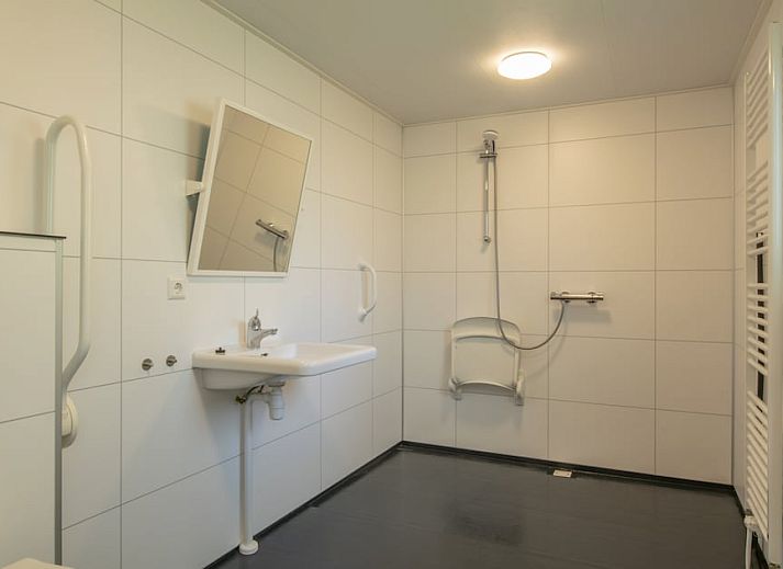 Gezellige woonkamer in Comfort 2 Mindervalide chalet, Kijkduin, met comfortabele zithoek en decoratie.