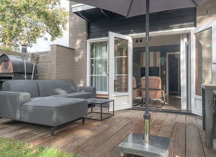 Bungalow Brouwersdam in Ouddorp biedt een ruim terras met comfortabele zitplaatsen en parasol, ideaal voor ontspanning in Goeree-Overflakkee.