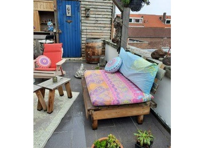 Entspannte Terrasse im Ferienhaus am Meer in Katwijk aan Zee, Nordseekueste, Suedholland, mit bunten Sitzgelegenheiten und Pflanzen.