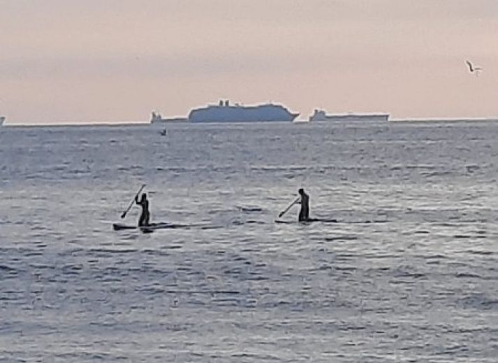 Aussenbereich des Ferienhauses am Meer, Katwijk aan Zee, Nordseekueste, Suedholland, mit Holzmoebeln und einer einladenden Atmosphaere.