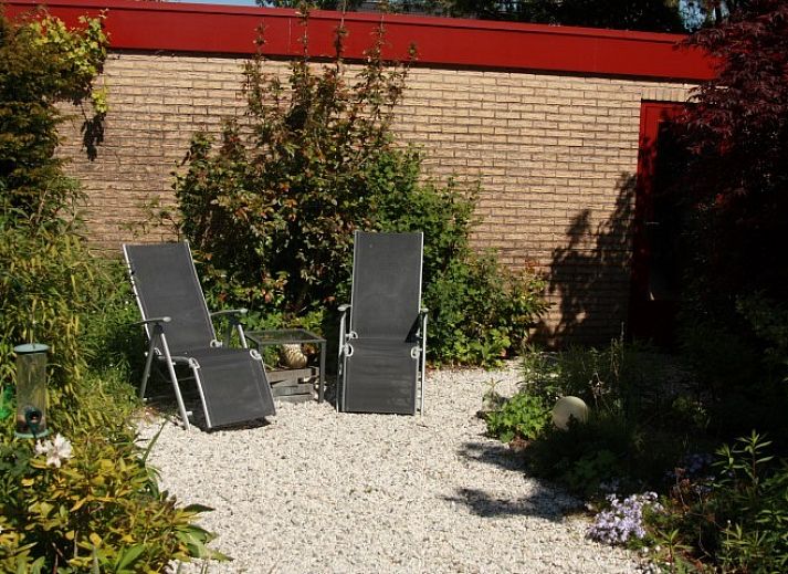 Om de Loop bungalow in Rockanje, Noordzeekust, met weelderige tuin en charmante buitenkant.