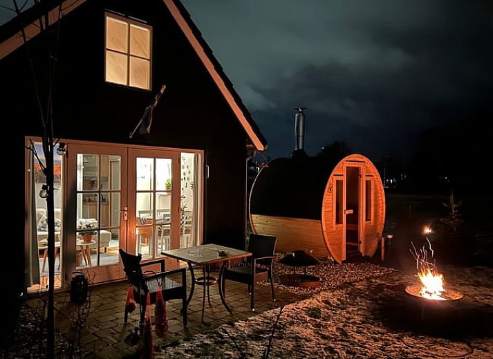 Lichte binnenruimte van Vakantiehuisje in Voorhout, Noordzeekust, met uitzicht op de tuin.