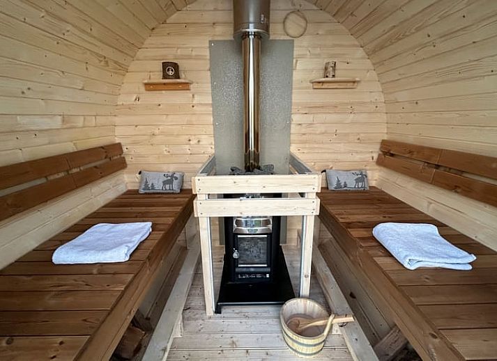 Stijlvolle binnenruimte van Vakantiehuisje in Voorhout, Noordzeekust, met houtkachel en decoratie.