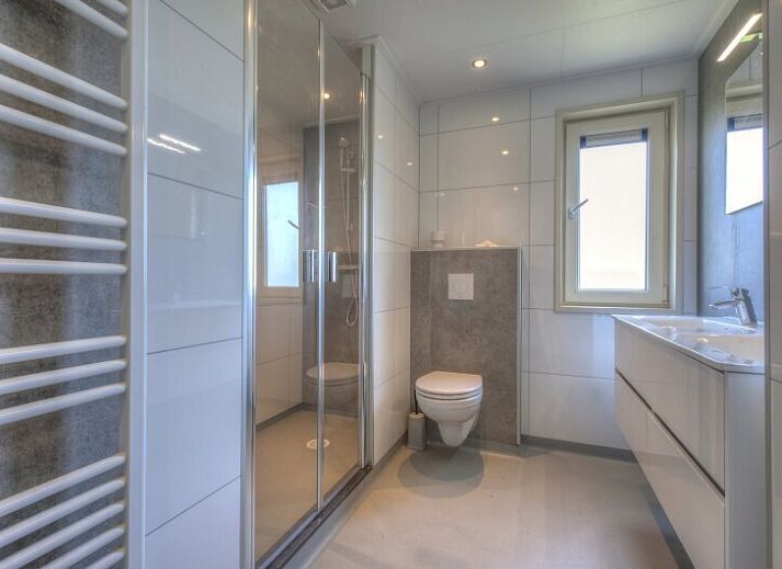 Lichte woonkamer in Chalet in Hellevoetsluis met uitzicht op de natuur van Voorne Putten.