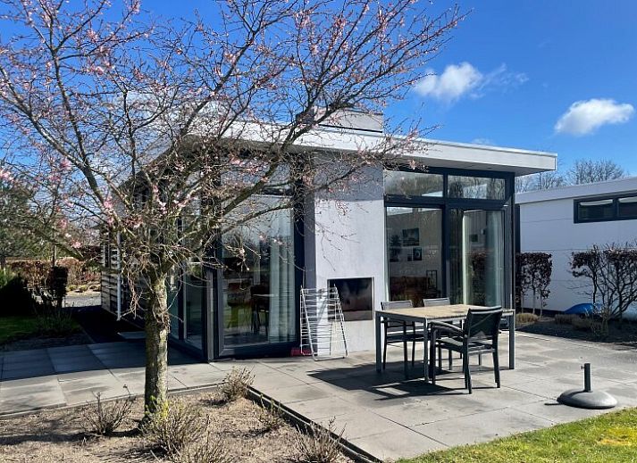 Lichte woonkamer in Chalet in Hellevoetsluis met uitzicht op de natuur van Voorne Putten.