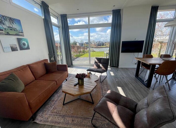 Lichte woonkamer in Chalet in Hellevoetsluis met uitzicht op de natuur van Voorne Putten.