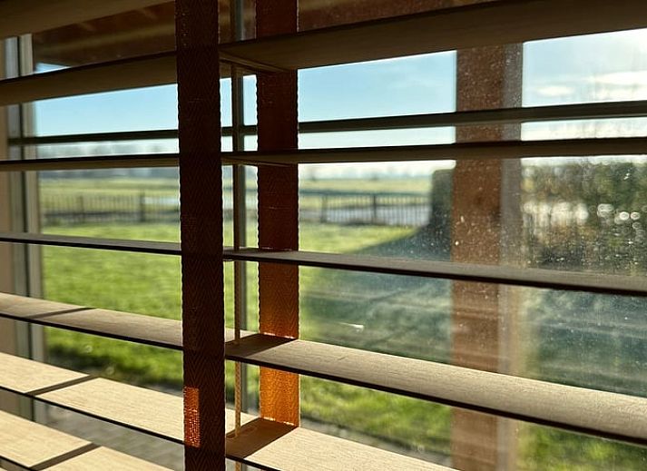 Lichte binnenruimte met houtkachel in Huisje in Strijen, vakantiehuis in Hoekse Waard, perfect voor ontspannen avonden.