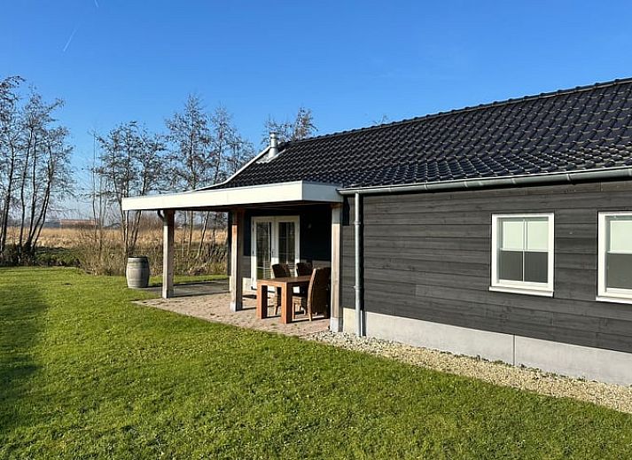 Lichte binnenruimte met houtkachel in Huisje in Strijen, vakantiehuis in Hoekse Waard, perfect voor ontspannen avonden.