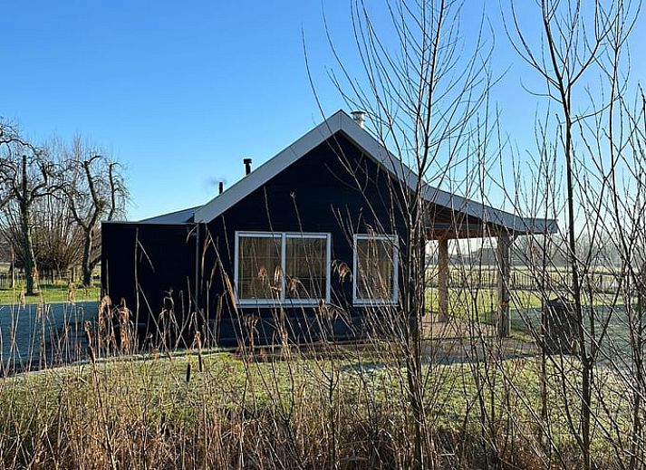 Lichte binnenruimte met houtkachel in Huisje in Strijen, vakantiehuis in Hoekse Waard, perfect voor ontspannen avonden.