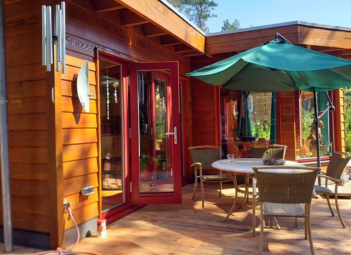 Vakantiehuisje in Groesbeek omringd door kleurrijke bloemen in het Rijk van Nijmegen, Gelderland.