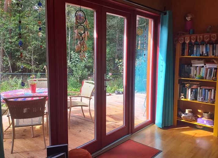 Terras van Vakantiehuisje in Groesbeek met parasol en zitplaatsen, ideaal voor ontspanning in Gelderland.