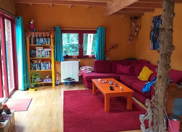 Terras van Vakantiehuisje in Groesbeek met parasol en zitplaatsen, ideaal voor ontspanning in Gelderland.