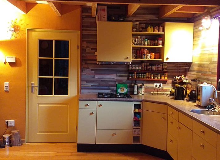 Terras van Vakantiehuisje in Groesbeek met parasol en zitplaatsen, ideaal voor ontspanning in Gelderland.