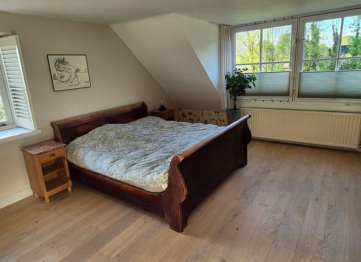 Spacious bedroom with wooden floor in Huisje in Overasselt, a cozy vacation home in Rijk van Nijmegen, Gelderland.