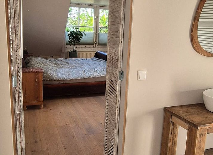 Spacious bedroom with wooden floor in Huisje in Overasselt, a cozy vacation home in Rijk van Nijmegen, Gelderland.
