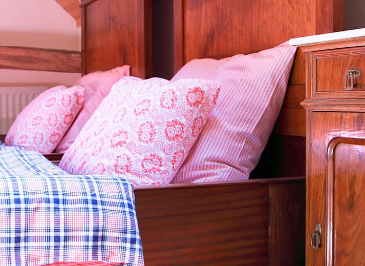 Charmanter Eingang zum Ferienhaus in Balgoij, Rijk van Nijmegen, Gelderland, umgeben von bluehenden Schlingpflanzen und historischen Backsteinen.