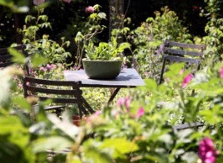 Charmanter Eingang zum Ferienhaus in Balgoij, Rijk van Nijmegen, Gelderland, umgeben von bluehenden Schlingpflanzen und historischen Backsteinen.